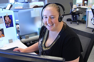 A smiling member of our Pharmacy Support team on a phone call