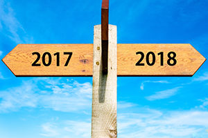 A road sign points to the year 2017 to the left and the year 2018 to the right