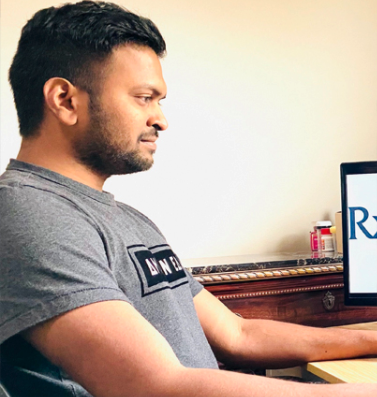 Vivek, a member of the Rx Savings Solutions team, working from home on his computer.